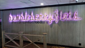 A wall with the sign 'Bumblebee Flies American Comfort Food' in illuminated letters. - The New Pioneer (Laughlin)