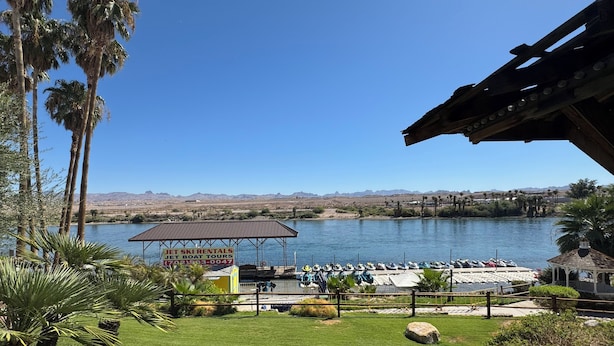 A marina with jet ski rentals, a covered seating area, and a view of a lake and mountains. - The New Pioneer (Laughlin)