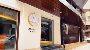 A modern building with a large glass window and a wooden facade. - Mira Otel Alsancak (Izmir)