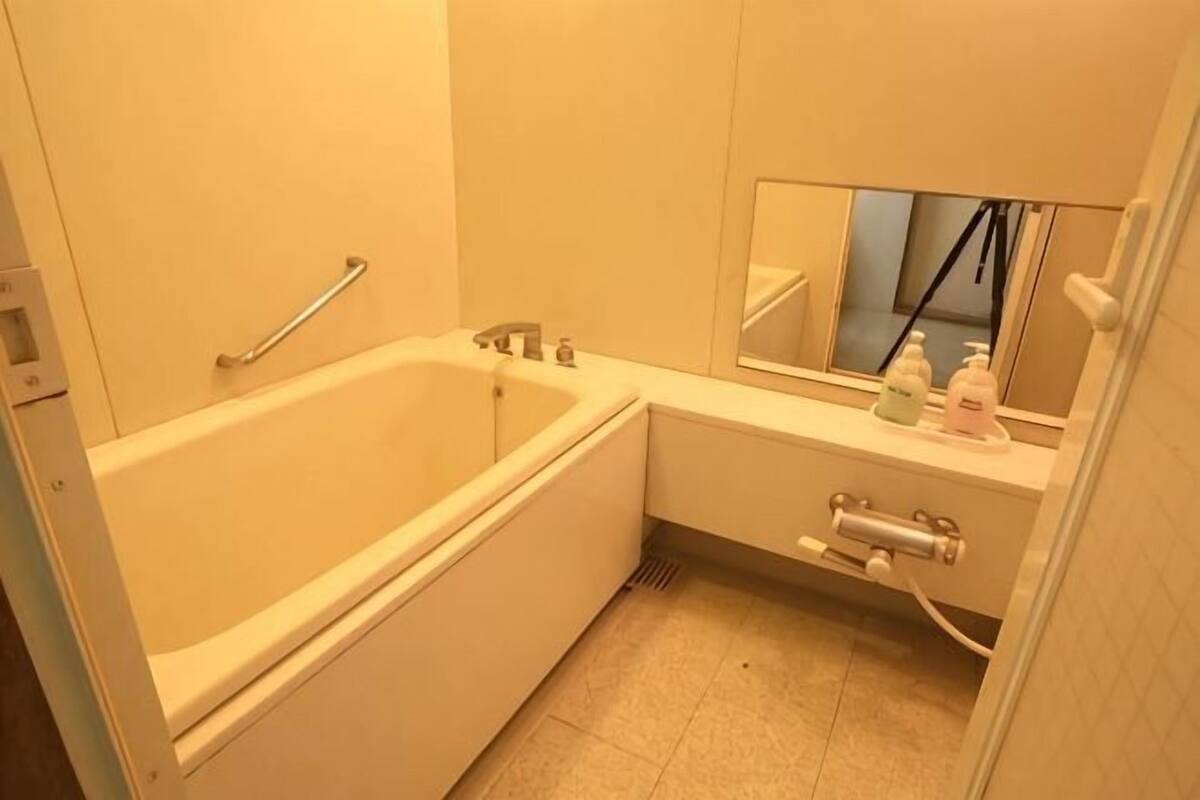 Ein Badezimmer mit Badewanne, Waschbecken, Spiegel und Pflegeprodukten.