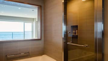 Een moderne badkamer met een bad, een glazen douchecabine en een grote spiegel.