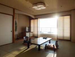 Una habitación japonesa tradicional con suelo de tatami, una mesa baja y puertas correderas shoji.