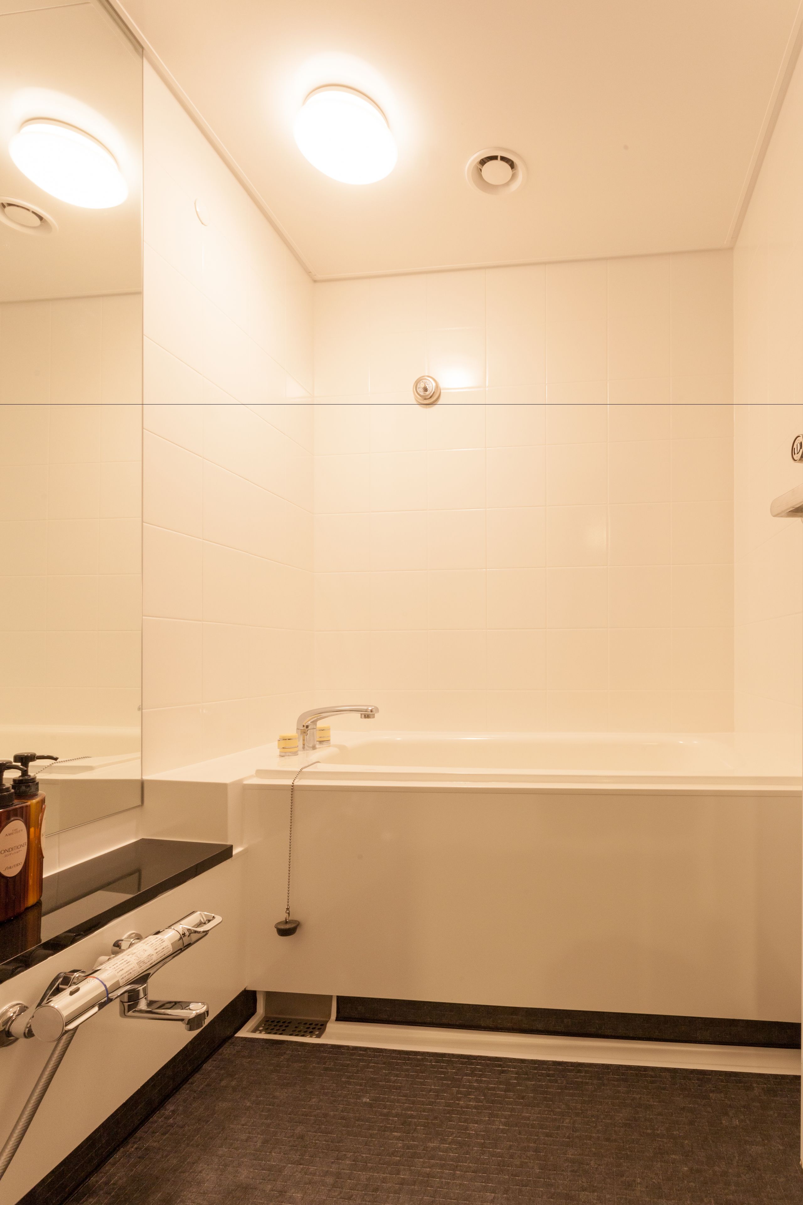 Un baño moderno con una bañera grande, un espejo y una zona de ducha.