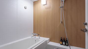 Un baño moderno con una bañera blanca, pared de paneles de madera y ducha con cabezal de ducha de mano.