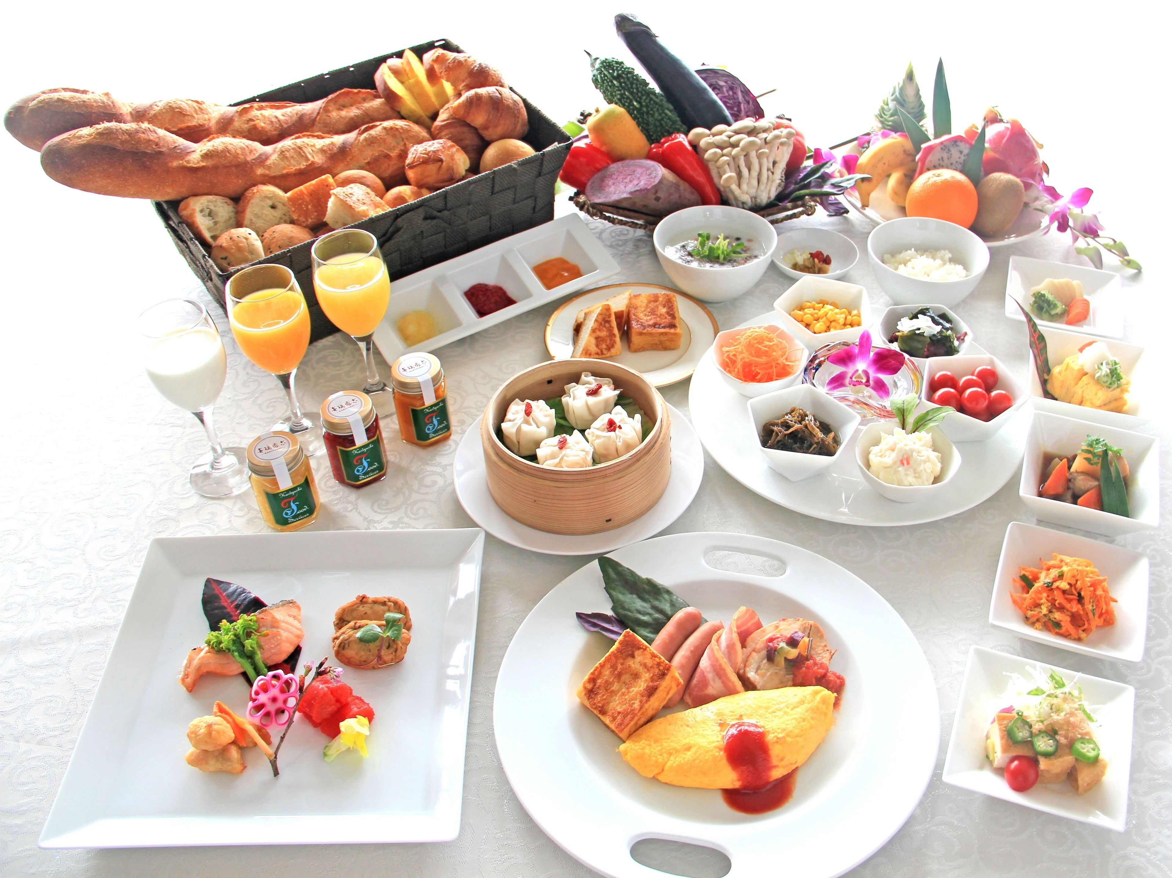 Variedad de productos para el desayuno, como pasteles, frutas y acompañamientos, sobre una mesa.