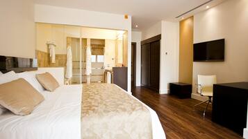 Une chambre d’hôtel moderne équipée d’un grand lit, d’un bureau, d’une chaise, d’une télévision et d’un miroir.