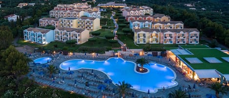 A resort with multiple buildings, a large central pool, and outdoor seating areas.