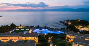 A resort with a swimming pool, villas, and a view of the sea at dusk. - Mareblue Beach - All Inclusive (Corfu)