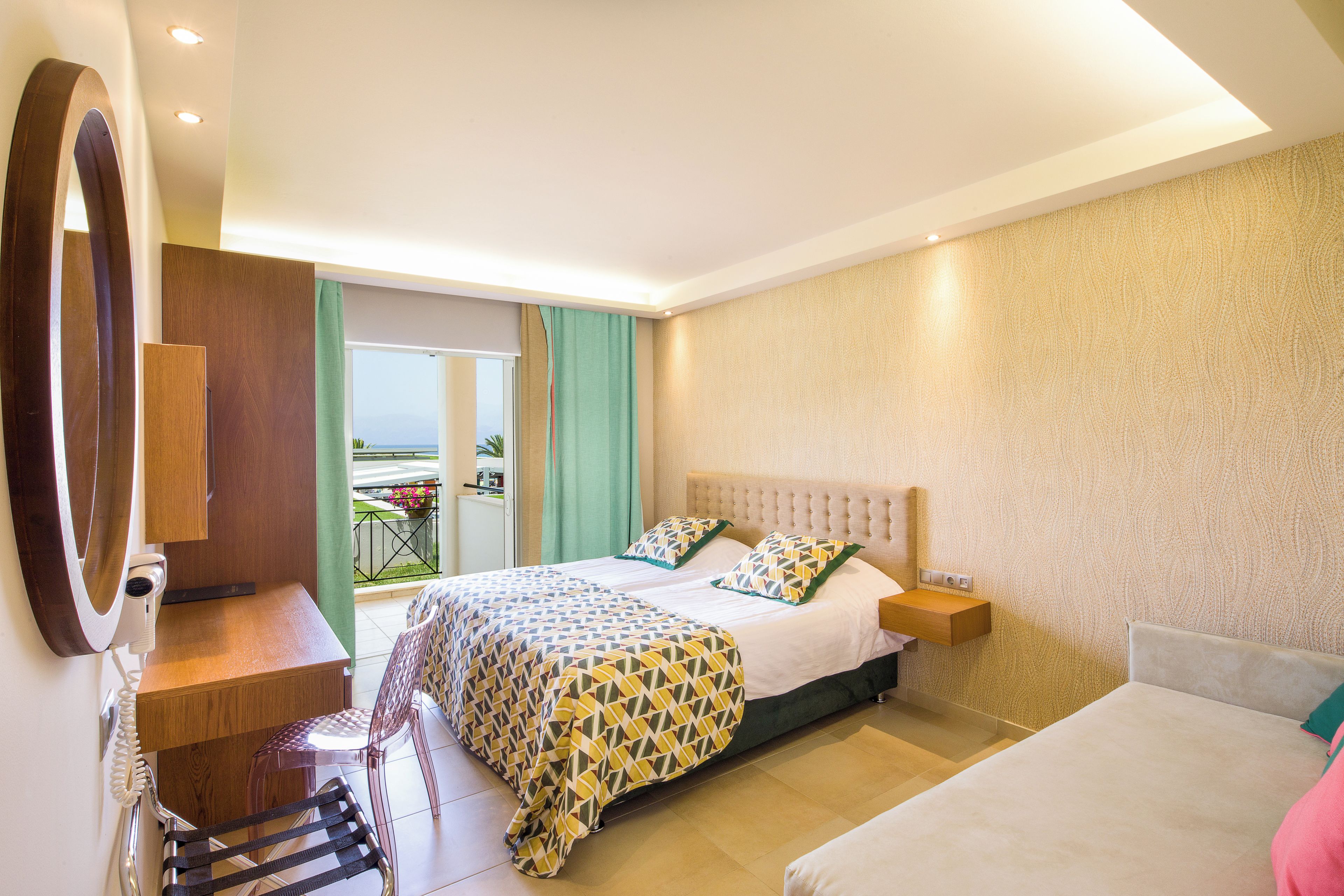 Een hotelkamer met een bed, een bureau, een stoel en een balkon met uitzicht.