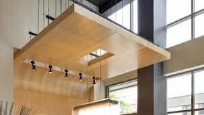 A modern indoor pool table with a wooden ceiling and pendant lighting, surrounded by large windows and minimalistic decor. - Aloft by Marriott New York Brooklyn (Brooklyn)