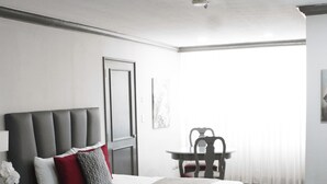 Une chambre d’hôtel moderne avec deux lits, un bureau et une chaise.