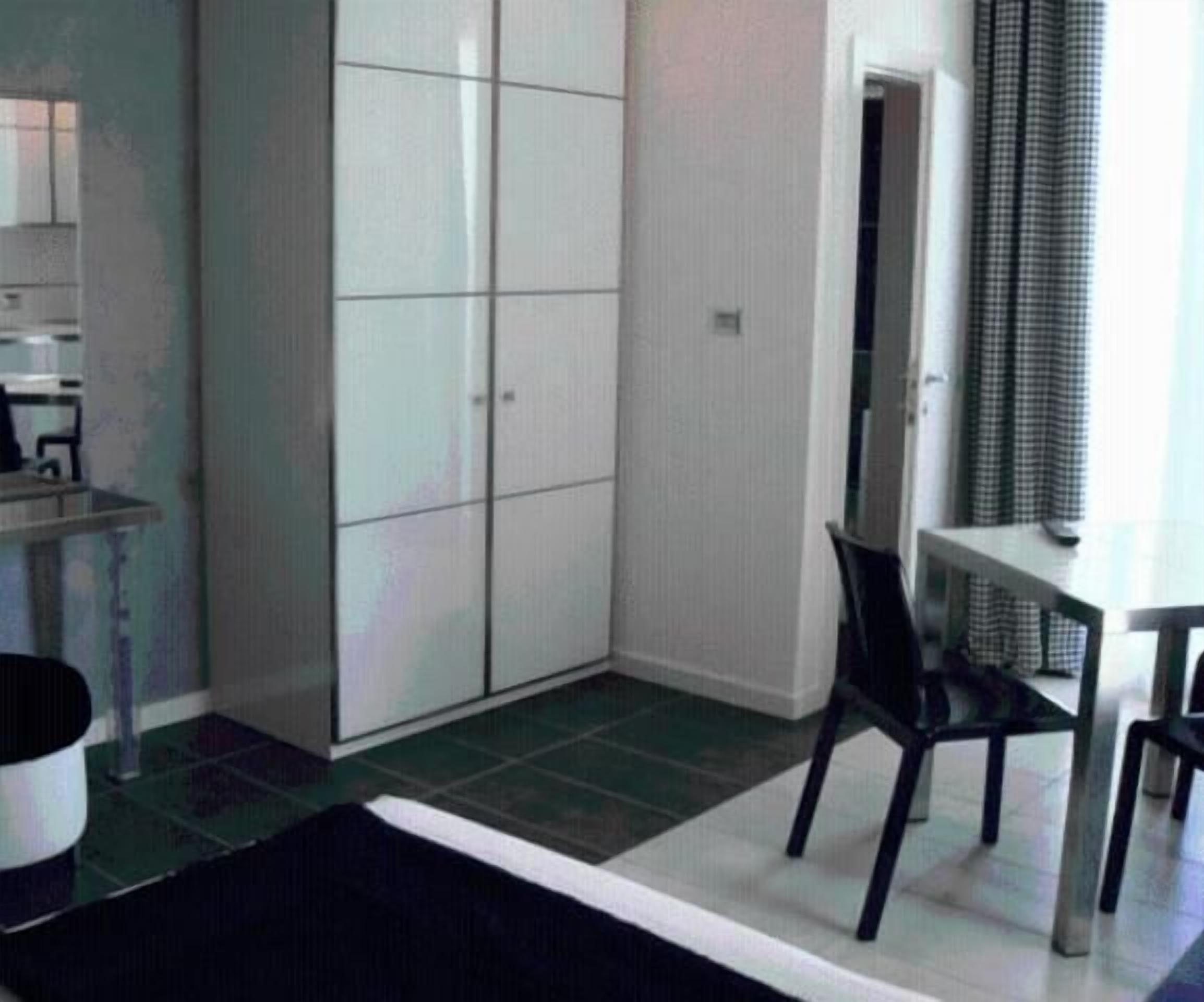 Une chambre avec un lit, un bureau, une chaise et une armoire.
