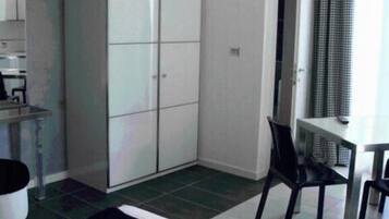 Une chambre avec un lit, un bureau, une chaise et une armoire.