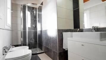 A modern bathroom with a shower, toilet, and vanity.