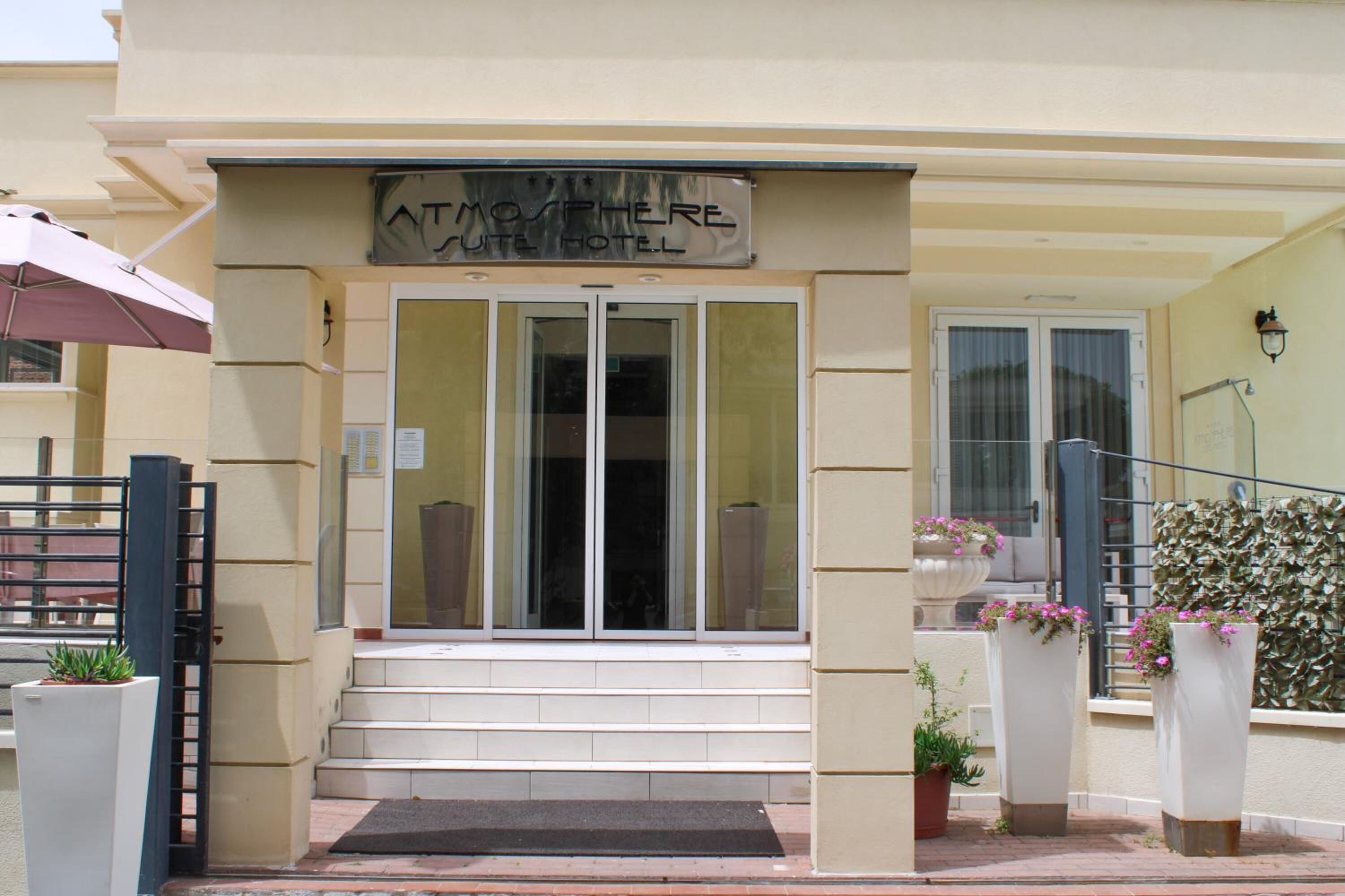 A hotel entrance with a sign reading "ATMOSPHERE HOTEL".