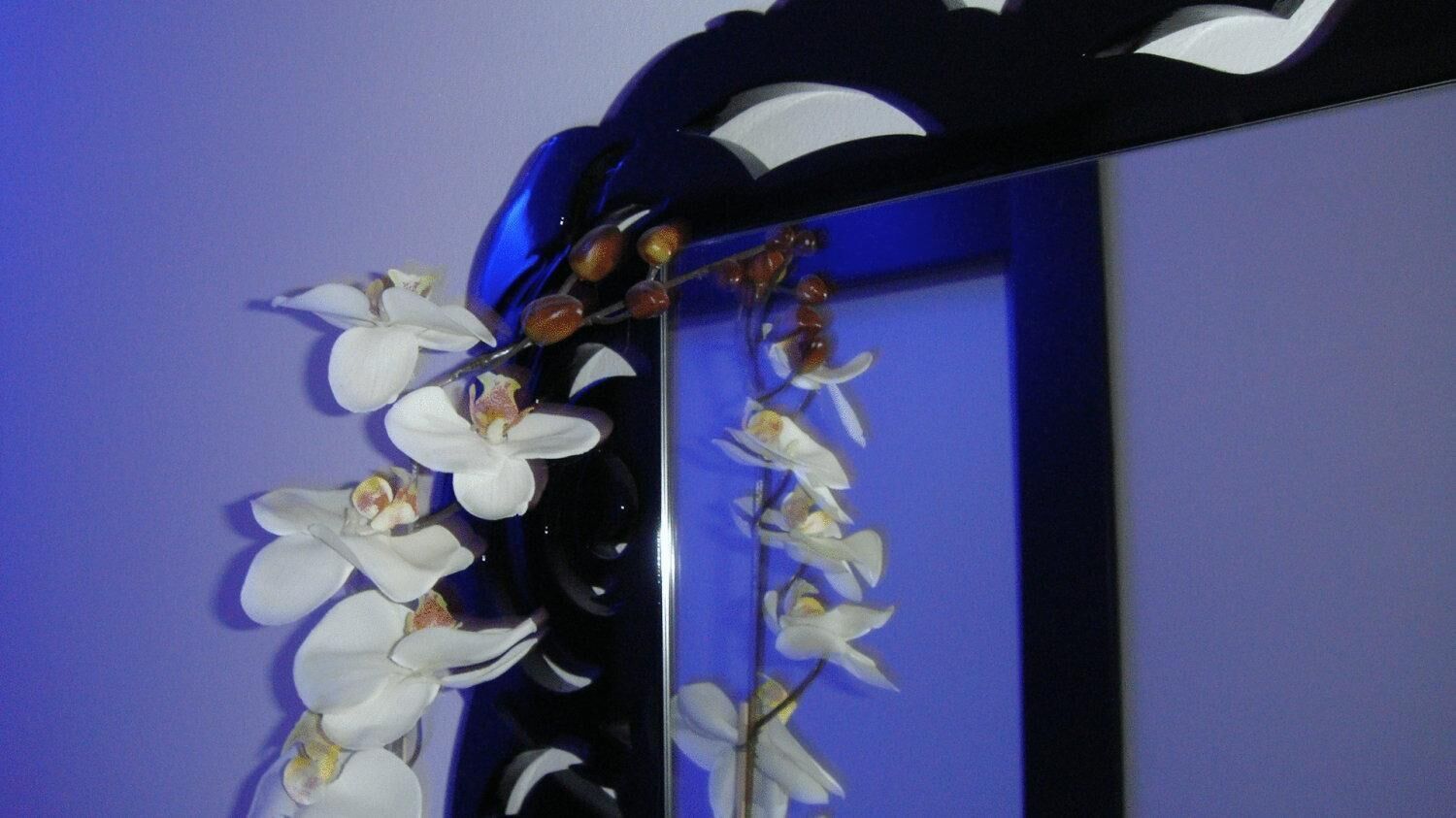 Sfondo blu con fiori di orchidea bianche e una struttura nera.