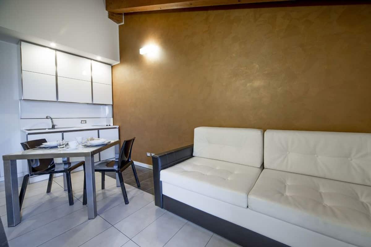 Un espace de vie compact comprenant un coin cuisine, un espace repas et un canapé.