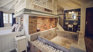 A bathroom with a stone sink, a wooden vanity, and a bathtub with a stone surround. - Villa Toscana Boutique Hotel - Adults only (Punta Ballena)