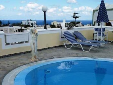 Una piscina al aire libre de temporada, sombrillas