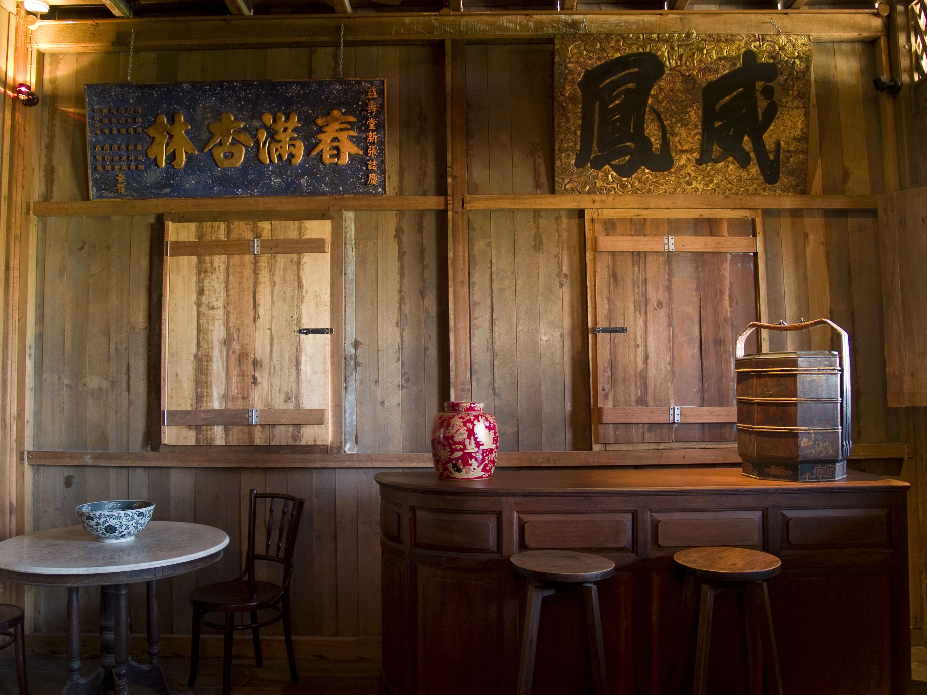 A traditional wooden interior with a table, chairs, and a decorative vase.