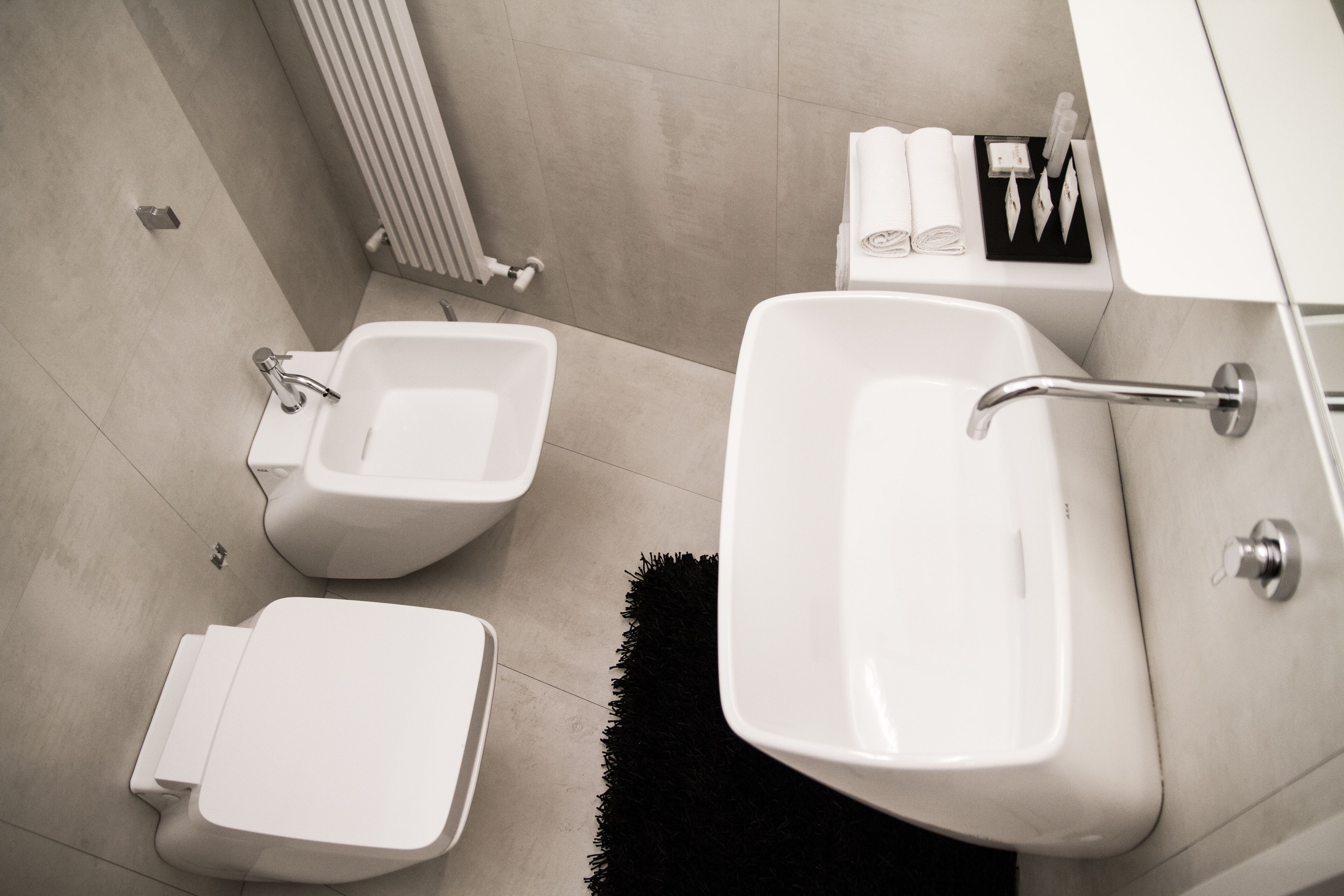 Une salle de bain moderne équipée d’un bidet, de toilettes et d’un lavabo.