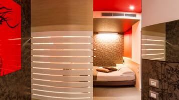 Ein Hotelzimmer mit Bett, Nachttisch und Spiegel.