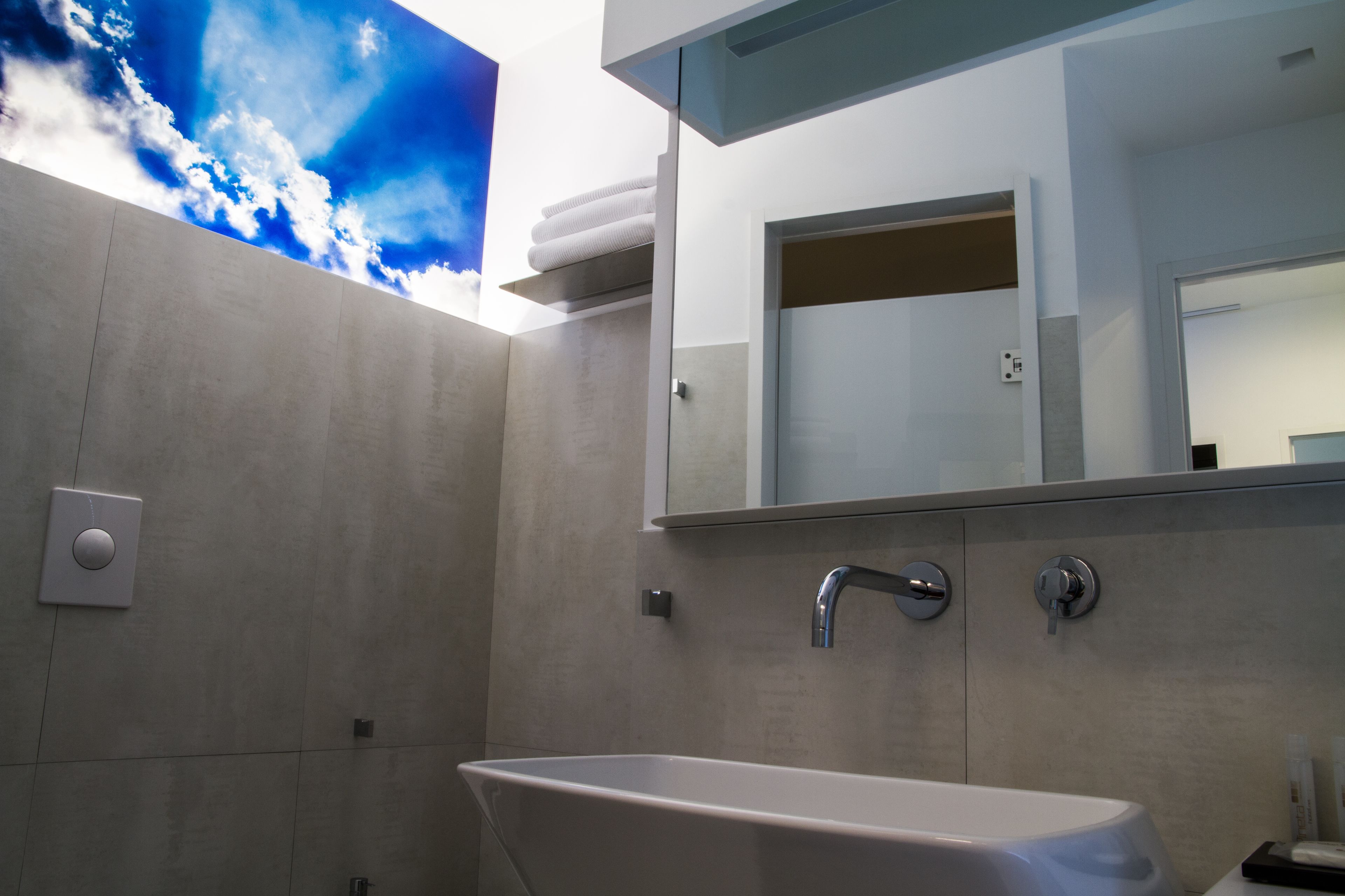 A modern bathroom with a freestanding bathtub, a large mirror, and a wall-mounted towel rack.