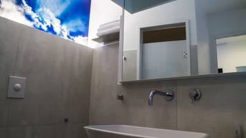 A modern bathroom with a freestanding bathtub, a large mirror, and a wall-mounted towel rack.