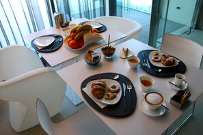 A dining table with plates of food, cups of coffee, and a bowl of nuts. - Pineta Hotel (Monsano)