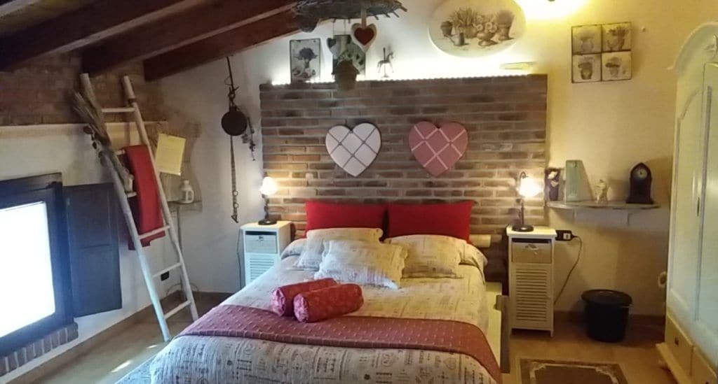 Een gezellige slaapkamer met een bed, een open haard en een bakstenen muur.