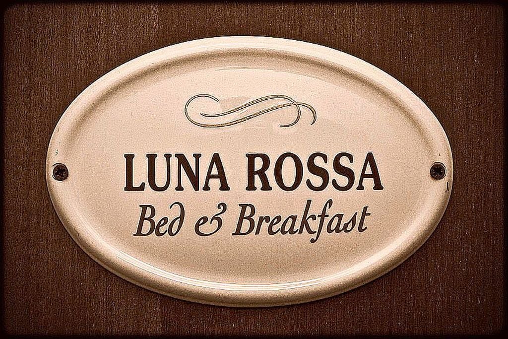 A sign with the text "LUNA ROSSA Bed & Breakfast".