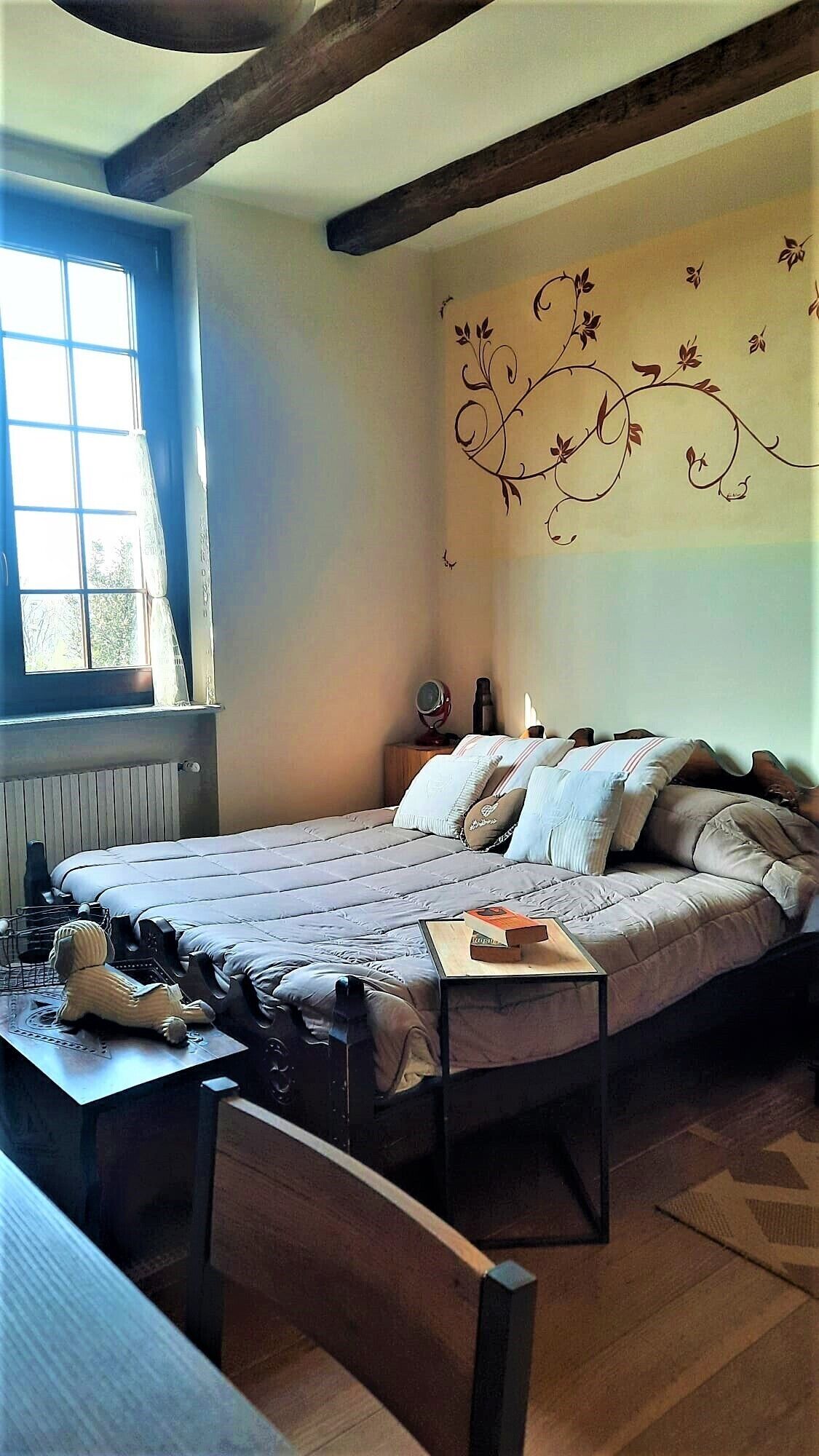 Une chambre à coucher avec un lit, une table de chevet et une fenêtre.