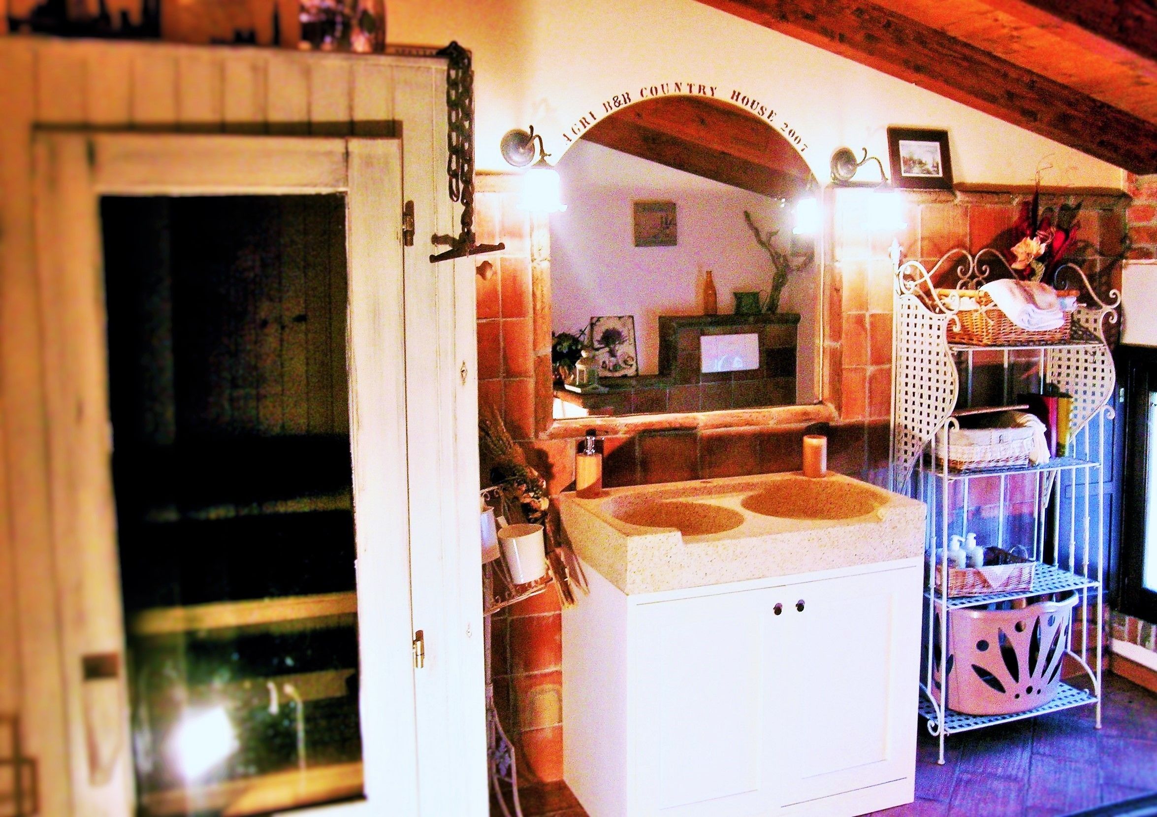 Una habitación con un lavamanos blanco, un espejo encima y una repisa con cestas.