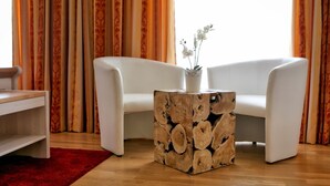 Un salon moderne avec un canapé blanc, une table basse en bois et un tapis rouge.