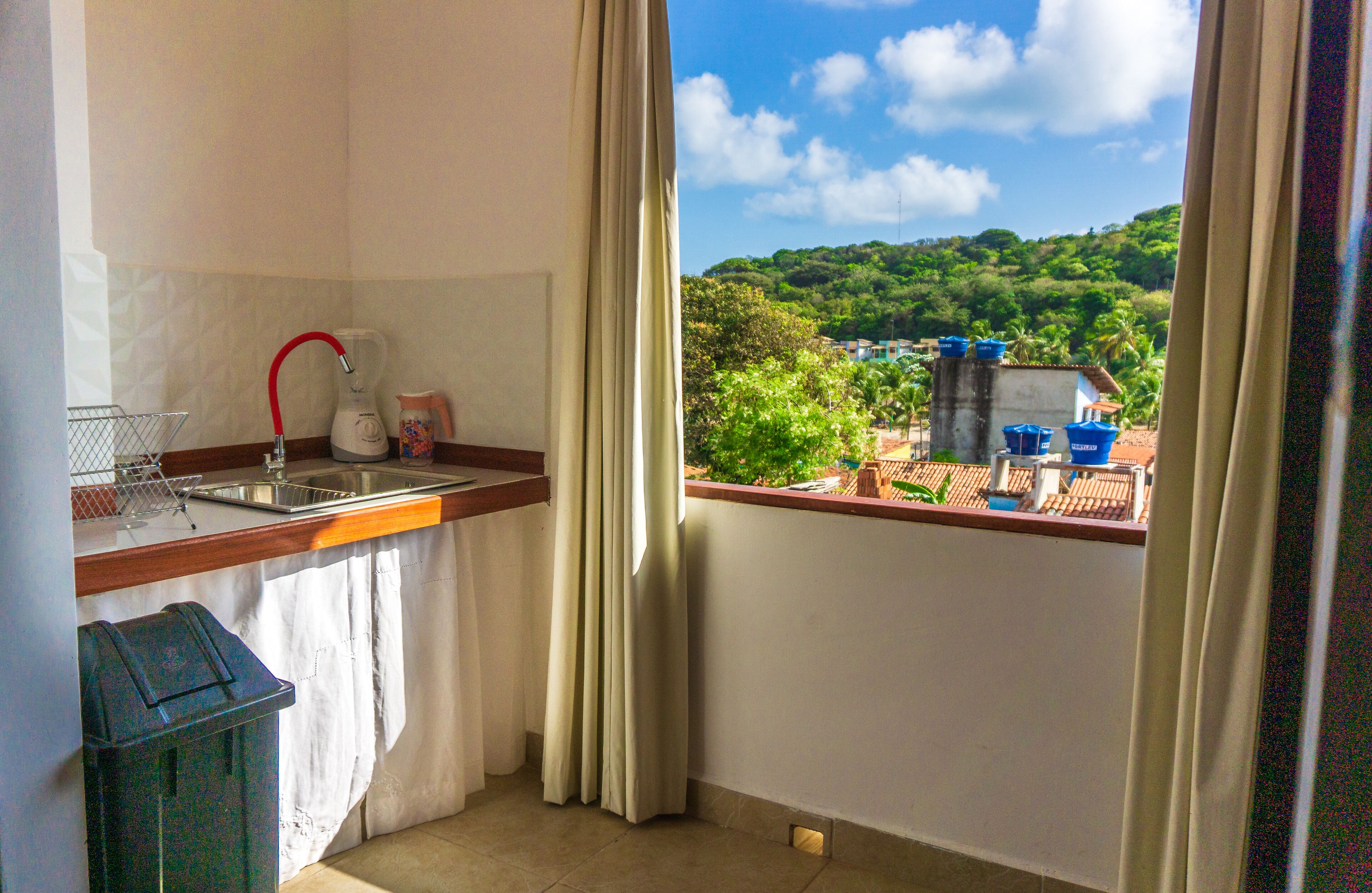 A small balcony with a kitchen area, including a sink and a kettle.