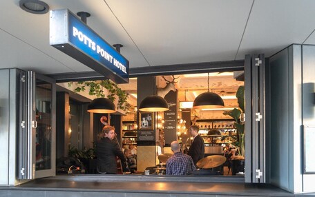 The exterior of the Potts Point Hotel with a visible entrance and a sign above the door.