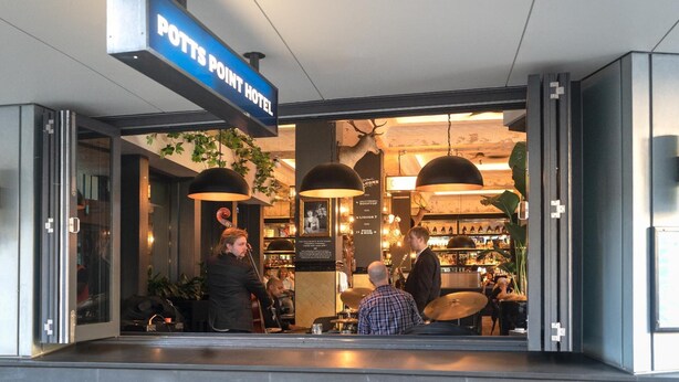 The exterior of the Potts Point Hotel with a visible entrance and a sign above the door. - Highfield Hotel (Potts Point)