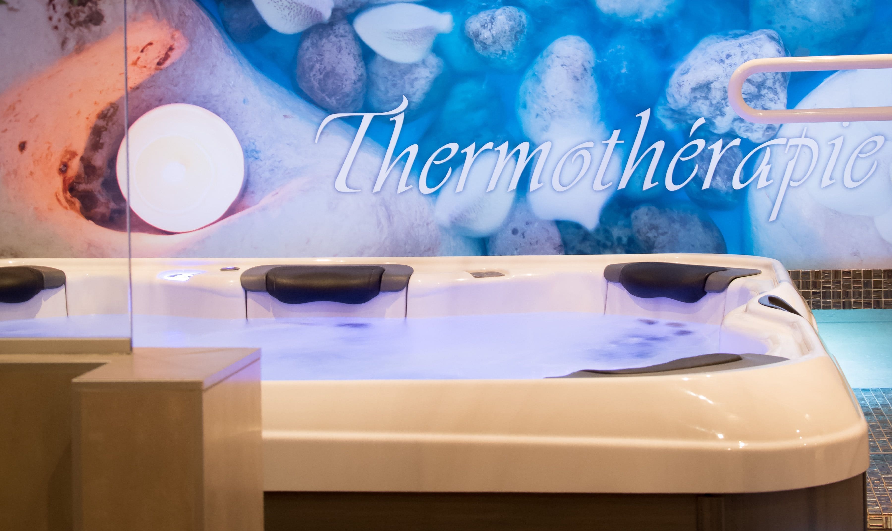 Un jacuzzi con un fondo que muestra la palabra "Thermothérapie".