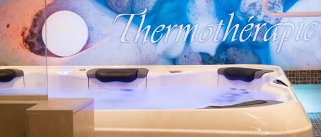 Een jacuzzi met op de achtergrond de tekst 'Thermothérapie'.