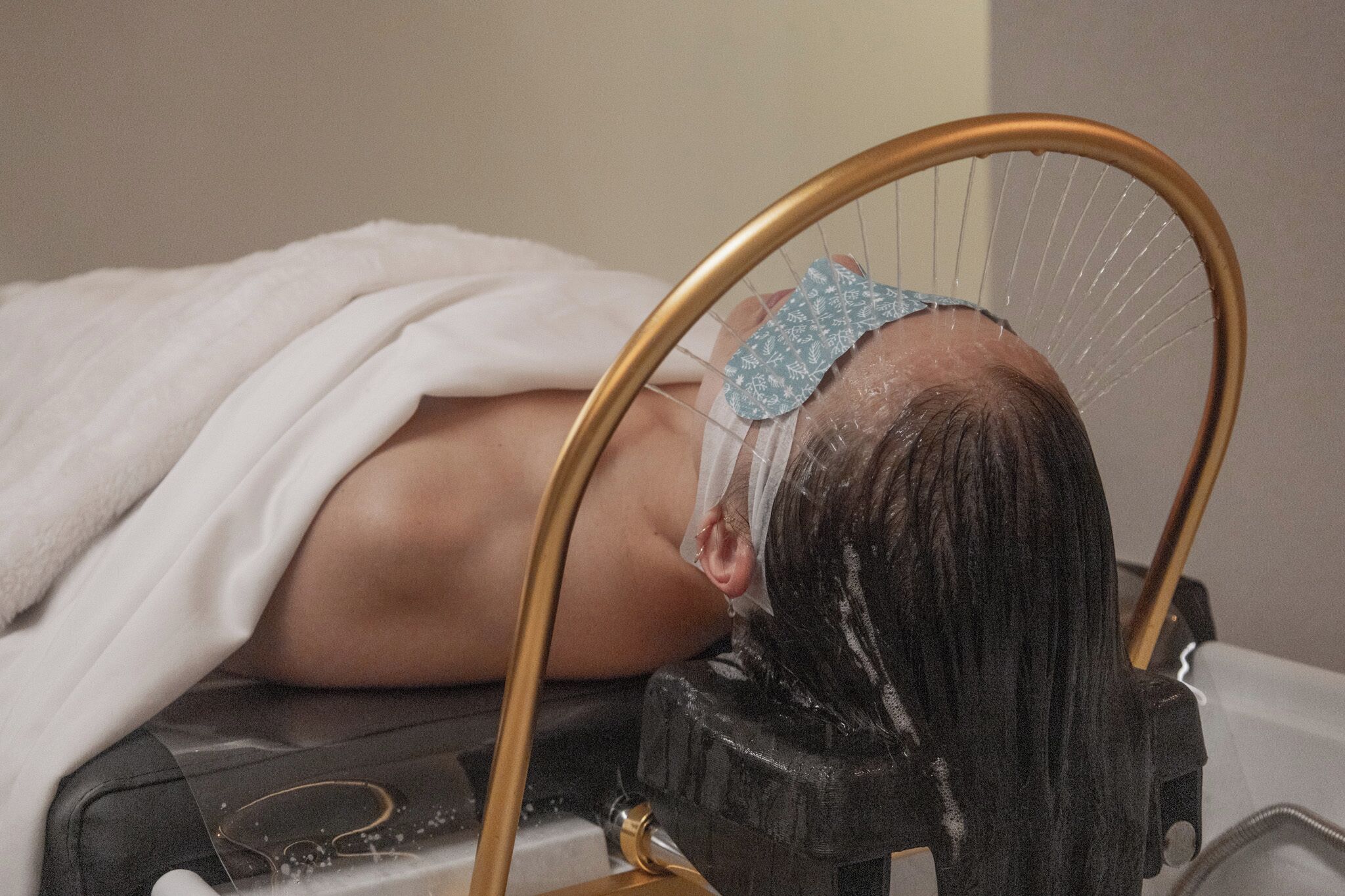 A person lying on a bed with a headrest.