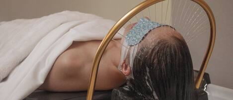 A person lying on a bed with a headrest.