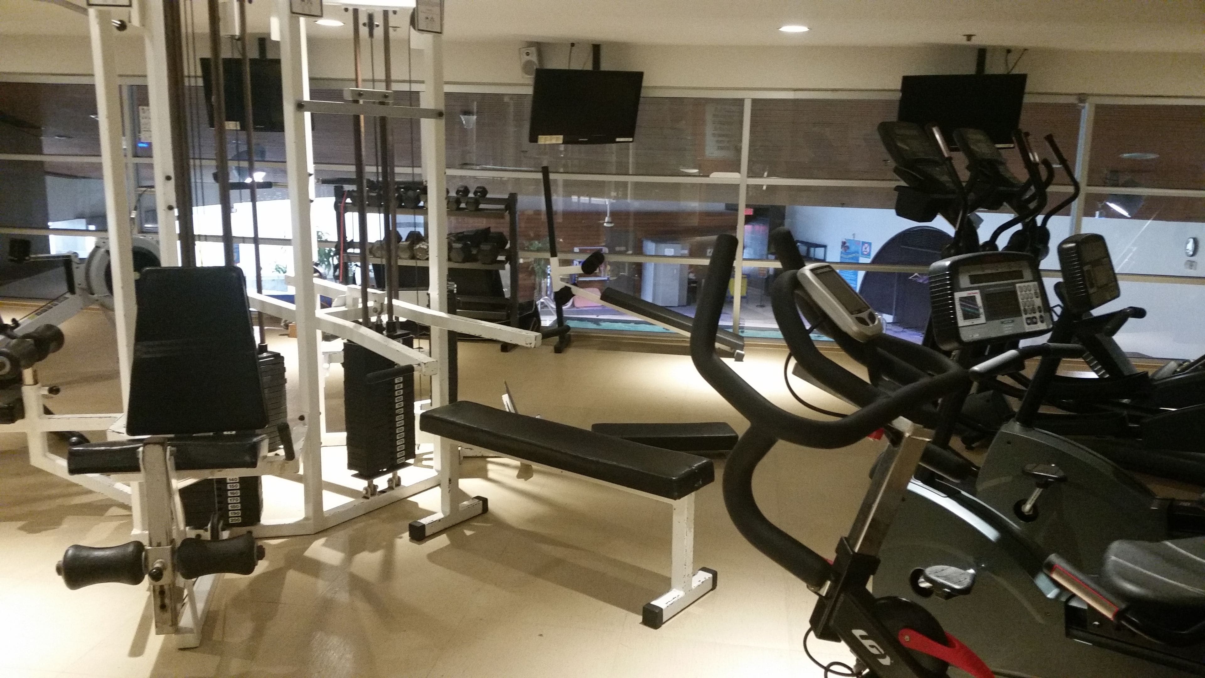 A gym with various exercise equipment, including treadmills and weight machines.