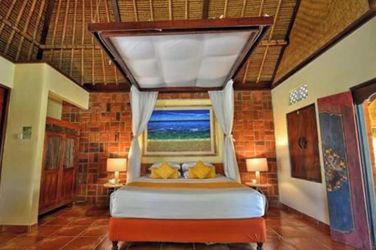 A room with a bed, a window with a painting, and a door.
