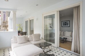 A modern living room with a sofa, a coffee table, and a view through a glass door to another room. - The Story Hotel Pera (Istanbul)