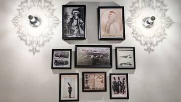 Paredes decoradas com fotografias históricas e militares emolduradas, incluindo tanques e um mapa.