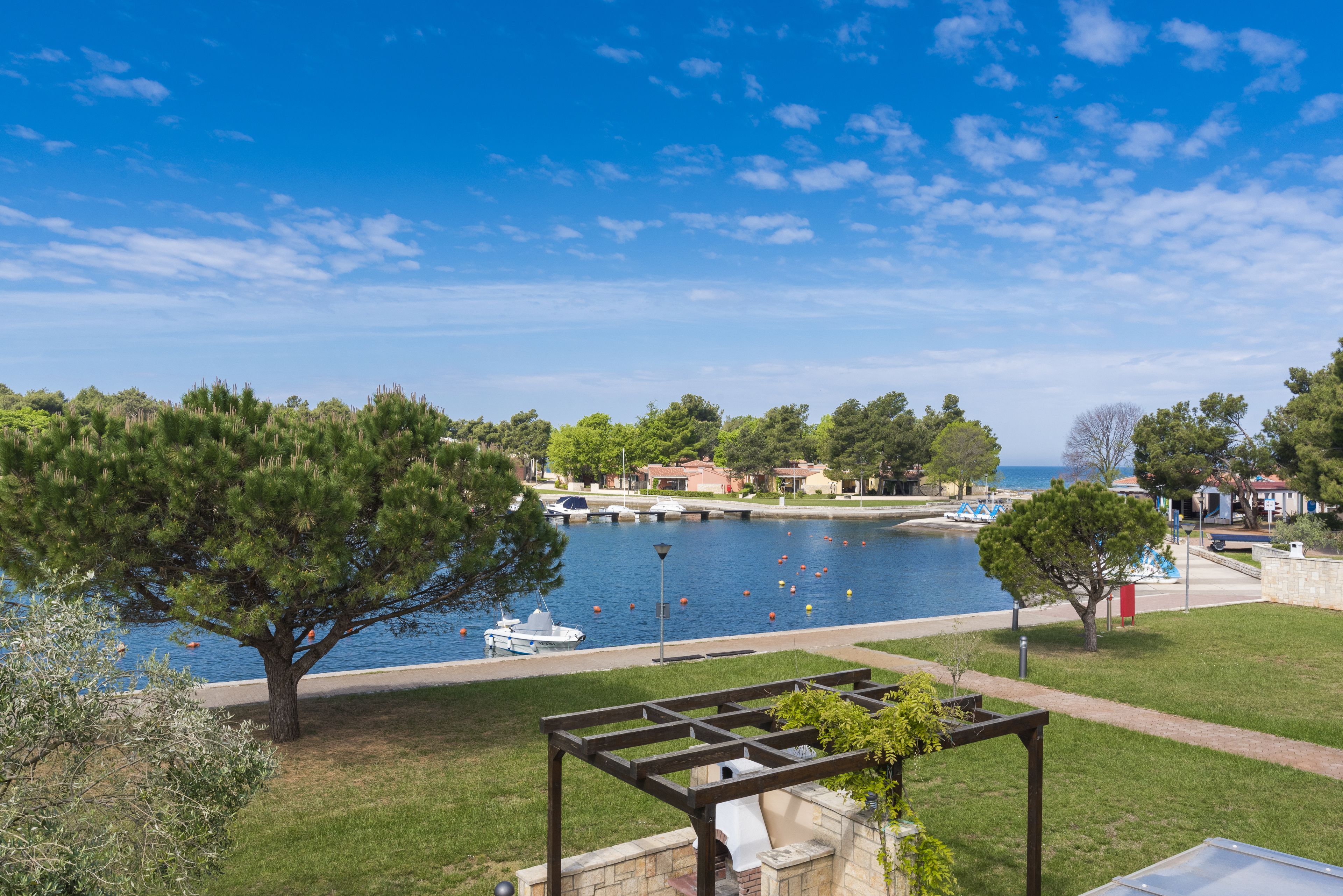 A waterfront view with a gazebo, a boat dock, and a marina.