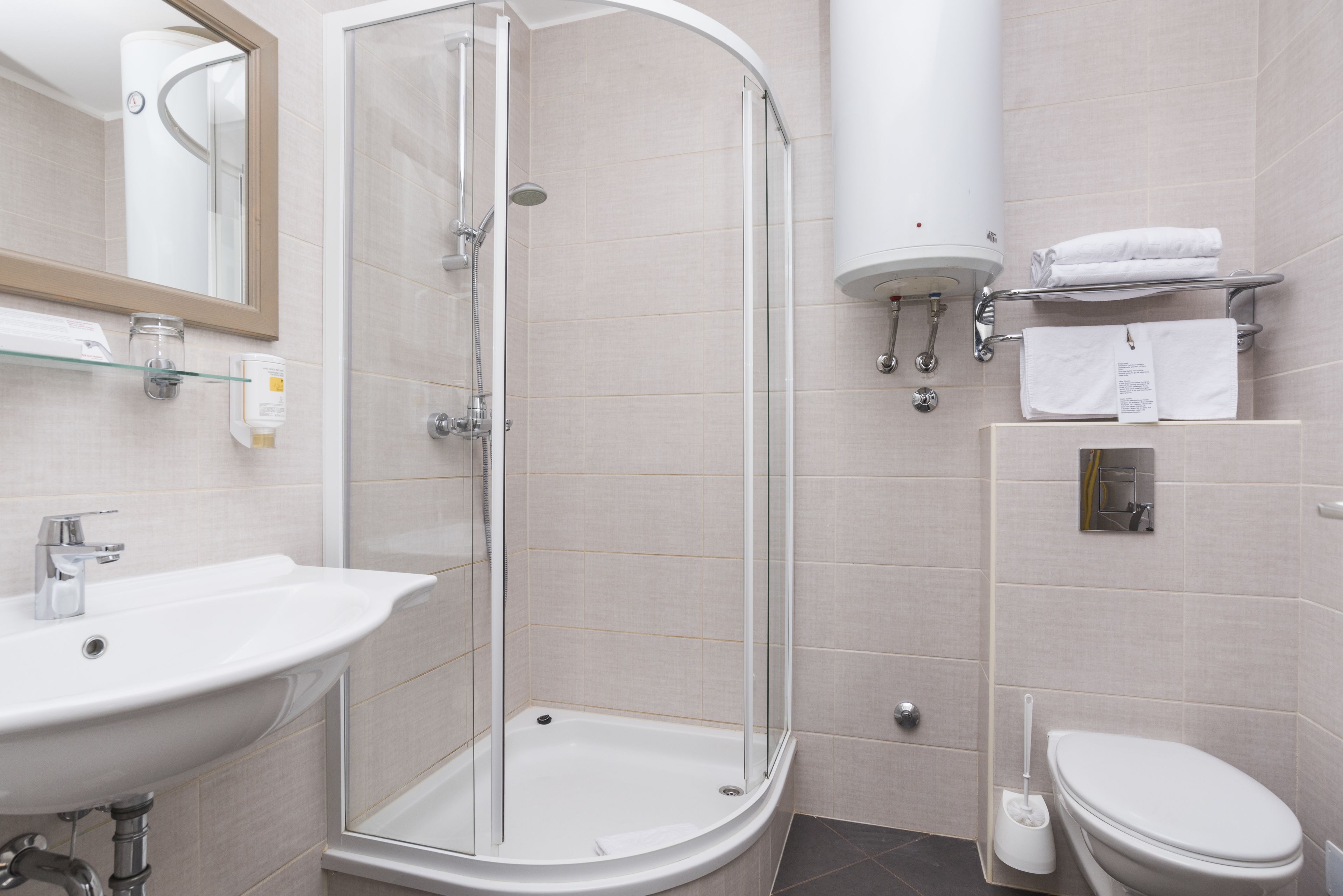 Une salle de bain moderne avec une douche à parois de verre, un lavabo, des toilettes et un miroir.