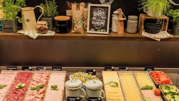 Un bufé con diversas opciones de comida, incluyendo carnes, quesos y verduras.