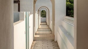 A corridor with arches, white walls, and a brick floor. - Maritalia Hotel Club Village - All Inclusive (Peschici)