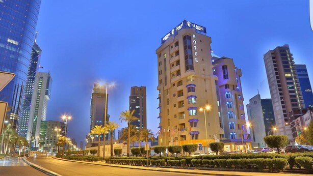 A hotel with a modern design, featuring a prominent 'HOTEL' sign on the facade. It is located in a cityscape with other high-rise buildings around.